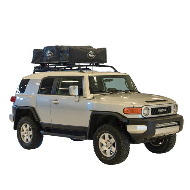 SUV with rooftop tent closed and gear packed on top