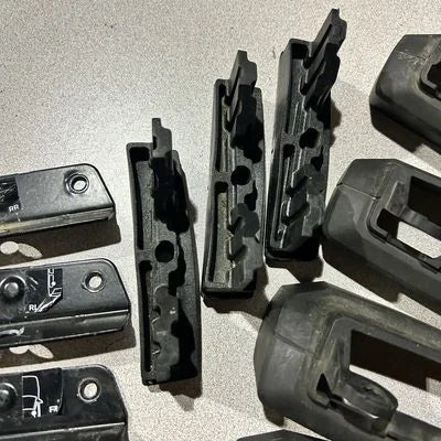Collection of black metal components on a gray surface