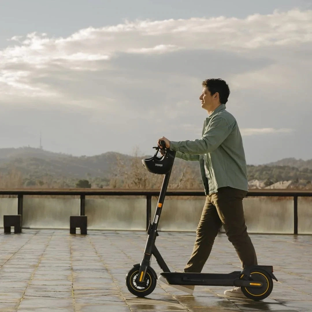 Person riding Segway Ninebot KickScooter Max G2 on a platform with mountain view in background
