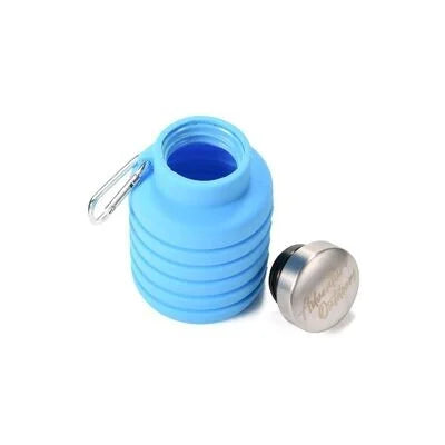 Light blue collapsible silicone water bottle partially collapsed with cap removed and placed nearby