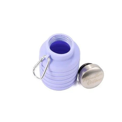 Purple collapsible silicone water bottle fully collapsed with cap removed and placed nearby