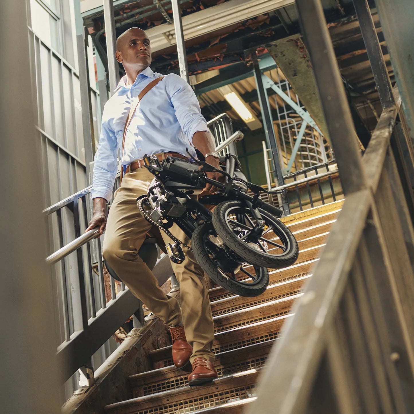 Man carrying folded Jetson Haze E-Bike down a stairwell