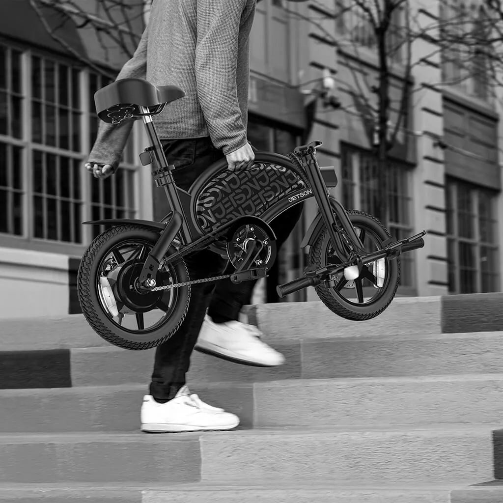 Person carrying folded Jetson Bolt Pro E-Bike up stairs