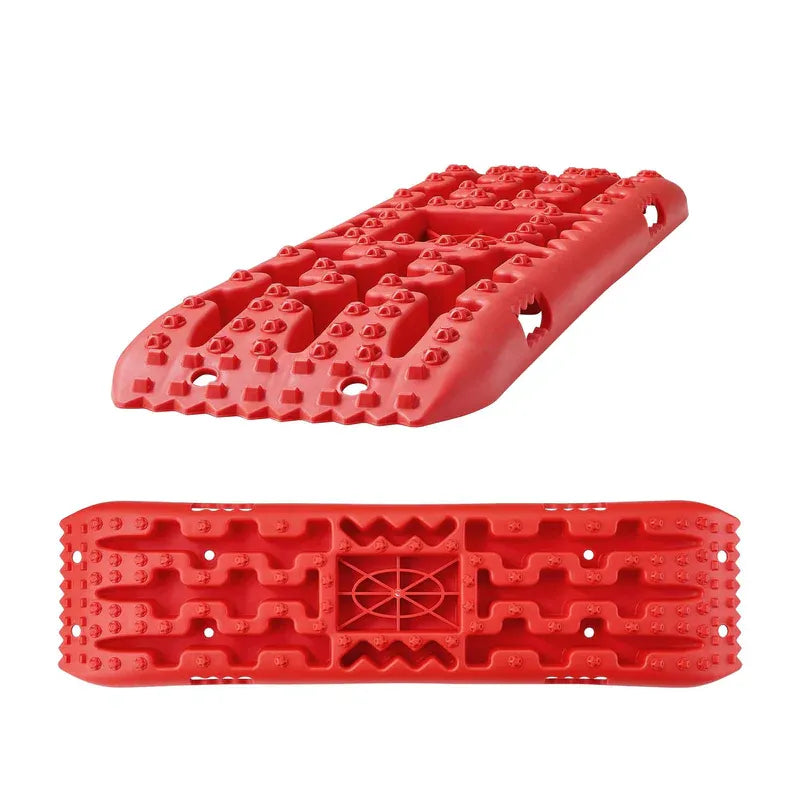 Side view of red recovery traction boards stacked, displaying large cleats and rugged construction.