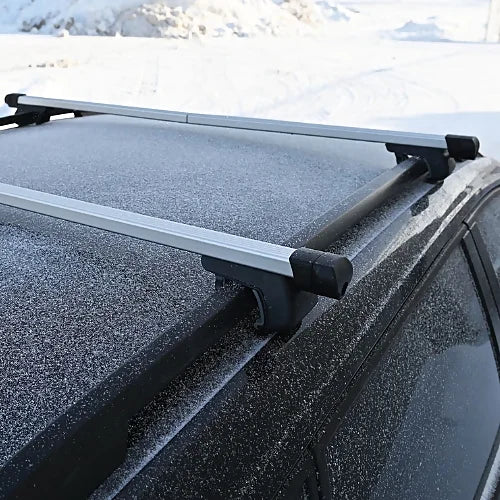 Rooftop crossbars installed on black SUV in winter setting with visible side rails