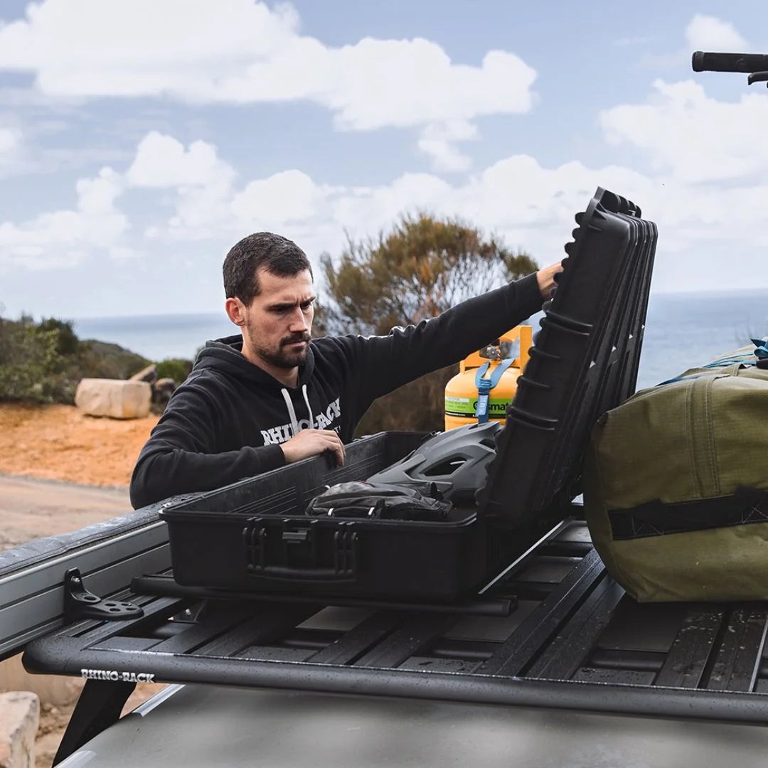 Person closing the lid of the Rhino-Rack Cargo Case after packing gear.