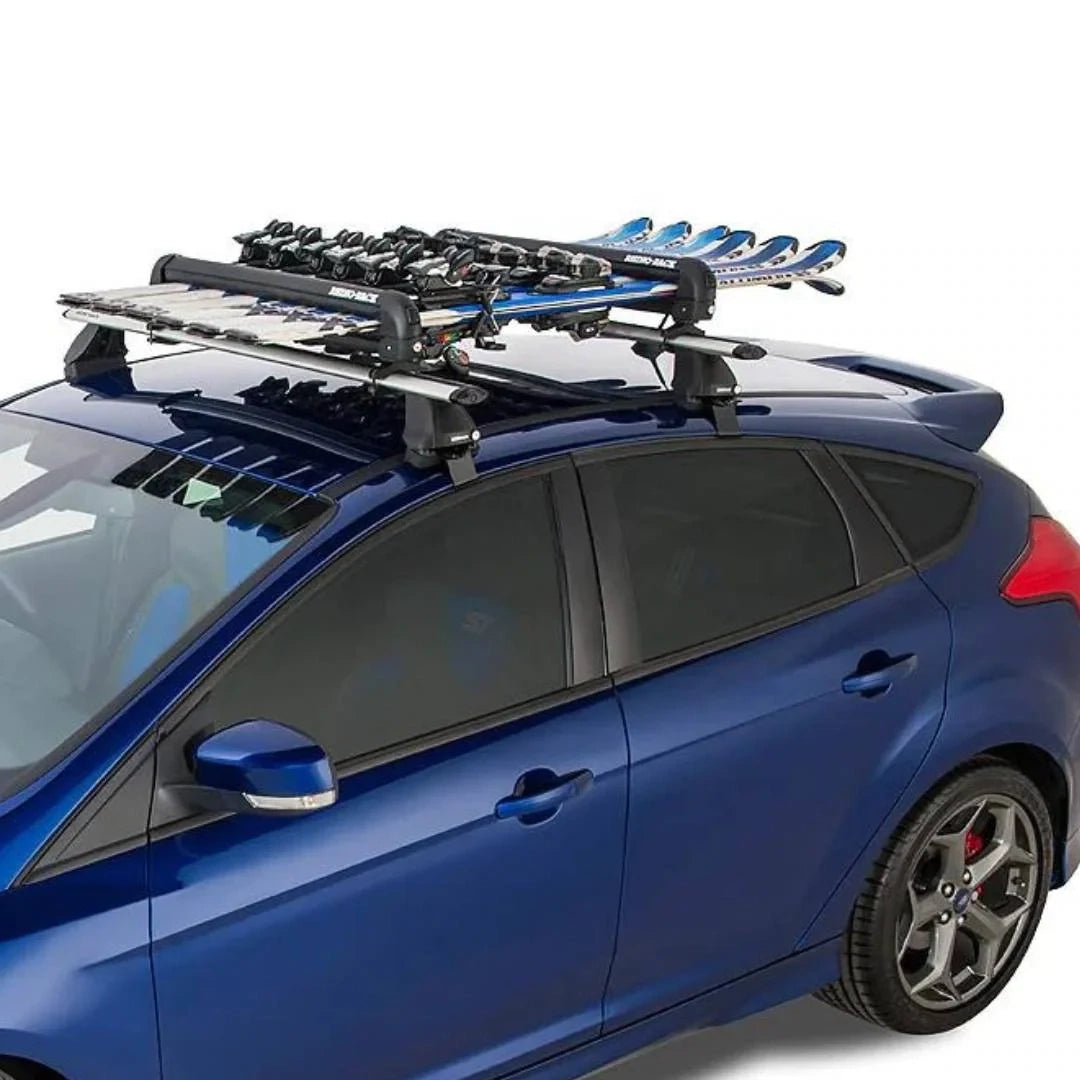 Rhino-Rack ski carrier installed on the roof of a blue car, carrying ski poles and snowboards.