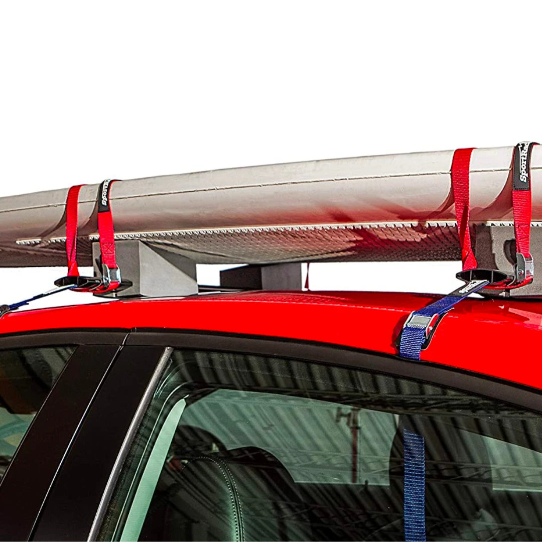 SportRack kayak carrier system holding a canoe on the roof of a red car using foam blocks and straps.