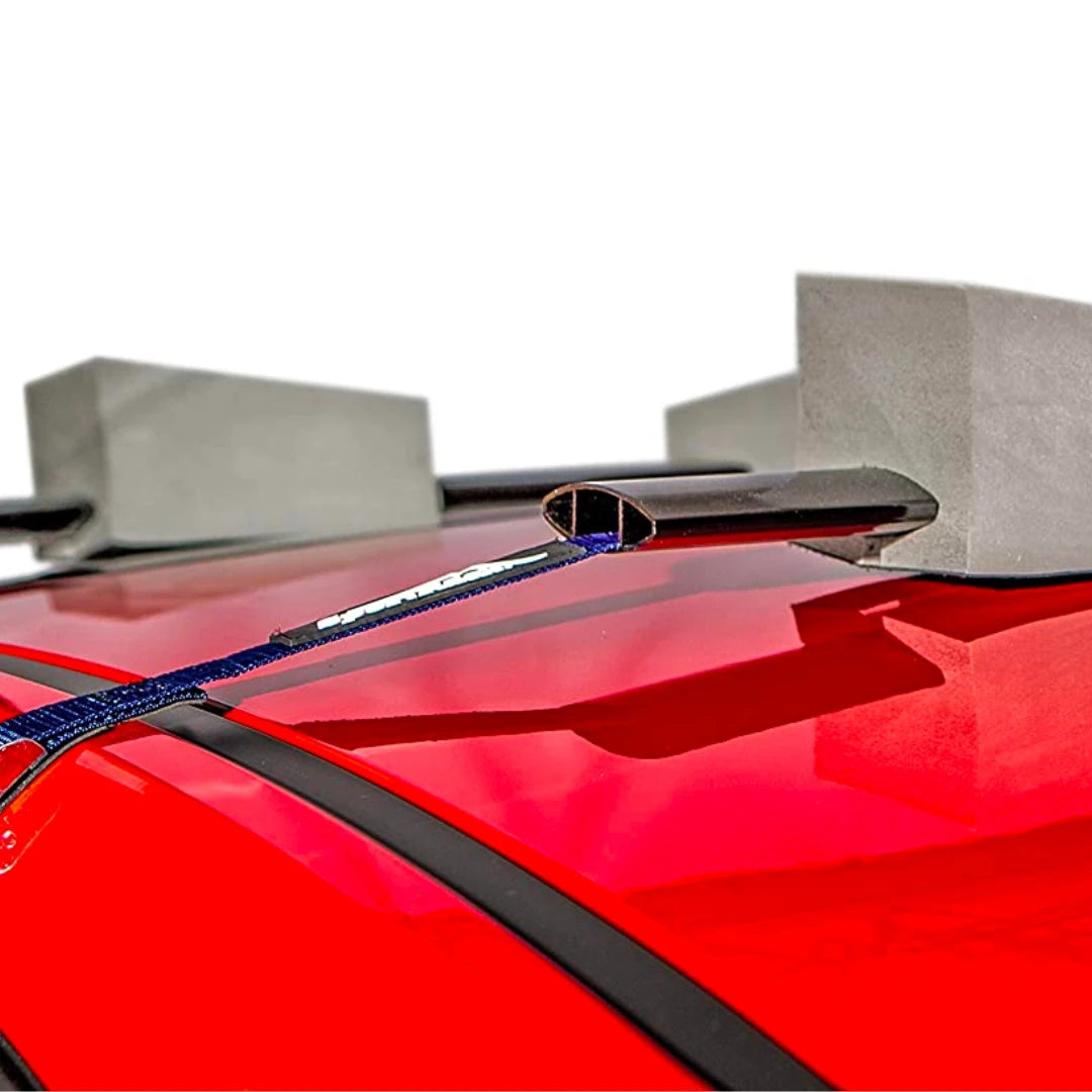 Close-up of SportRack adjustable foam block and strap securing a kayak on a car roof.