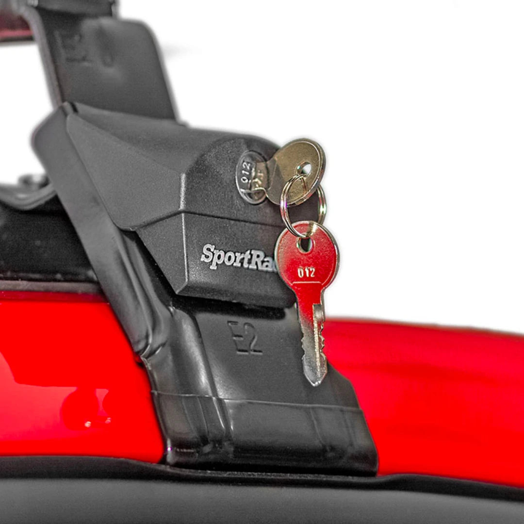SportRack Flush Roof Rack foot showing locking mechanism with inserted keys on red vehicle.