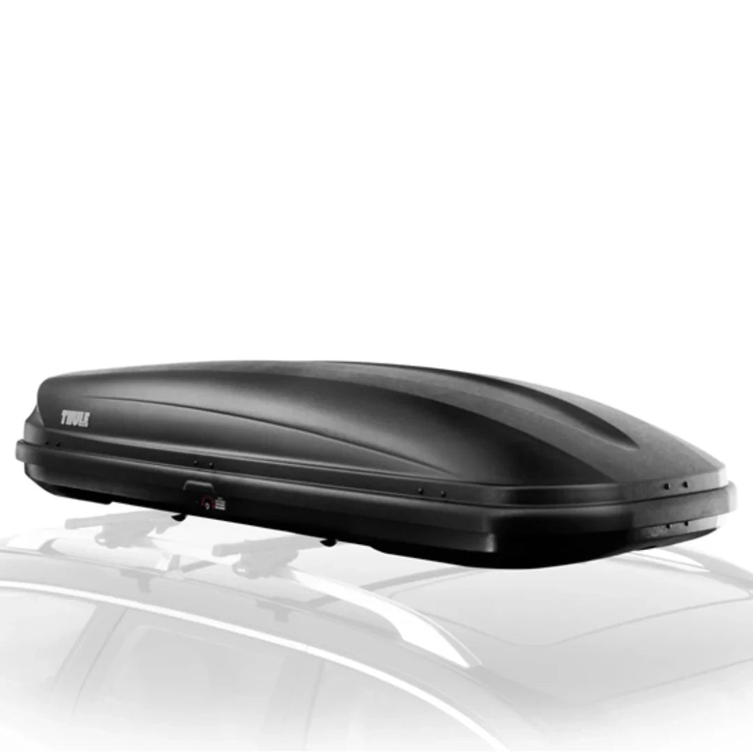 Angled side view of the Thule Ascent cargo box mounted on a car, emphasizing the low-profile design and rack compatibility.