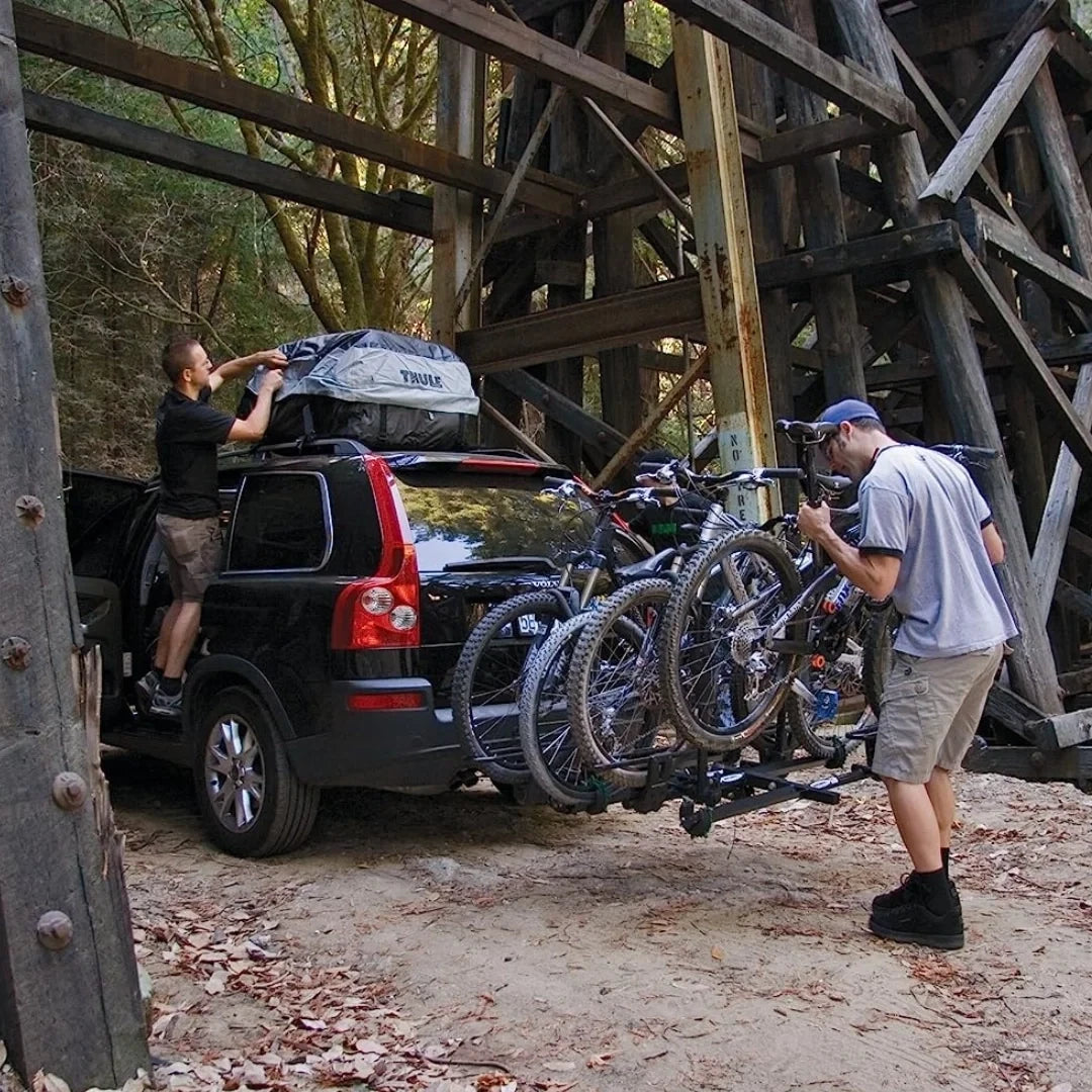 SUV parked outdoors with Thule Escape II cargo bag and multiple bikes mounted on rear rack