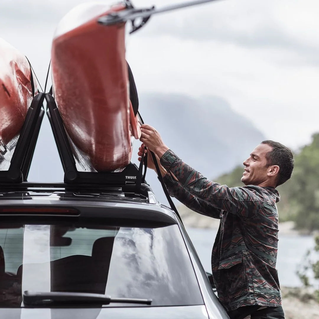 Thule Hull-a-Port Aero Kayak Rack
on car roof. Man loading kayaks onto it