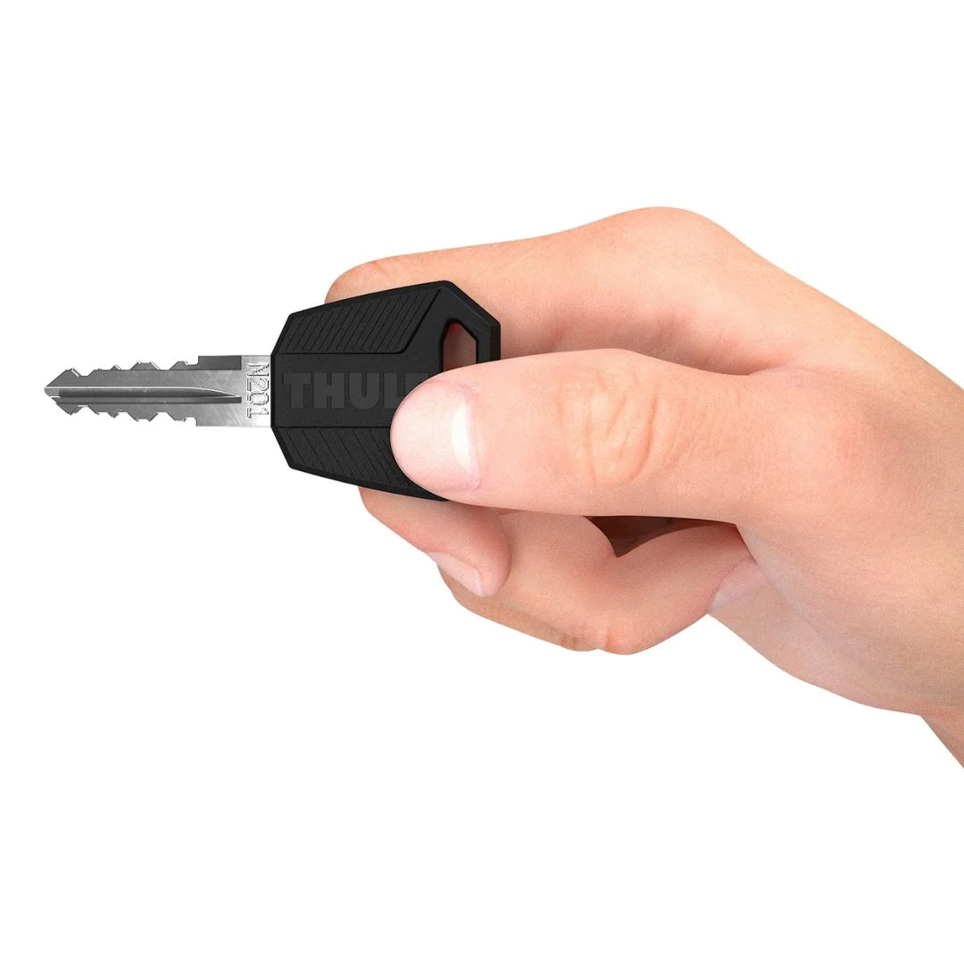 Hand holding a black key with a visible brand logo on a white background