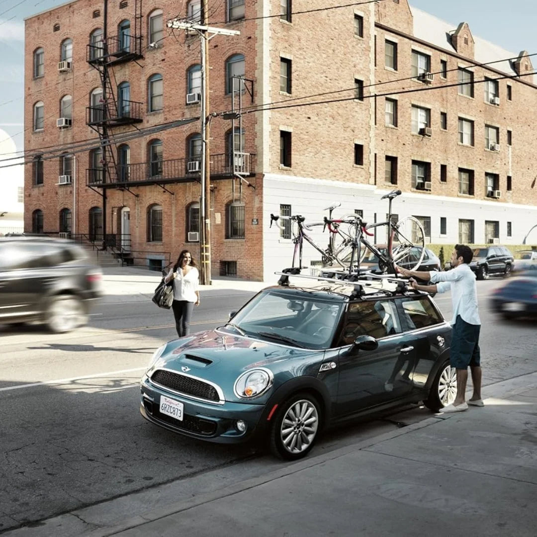 Car with Thule Outride rack and bike parked on city street with brick buildings in background
