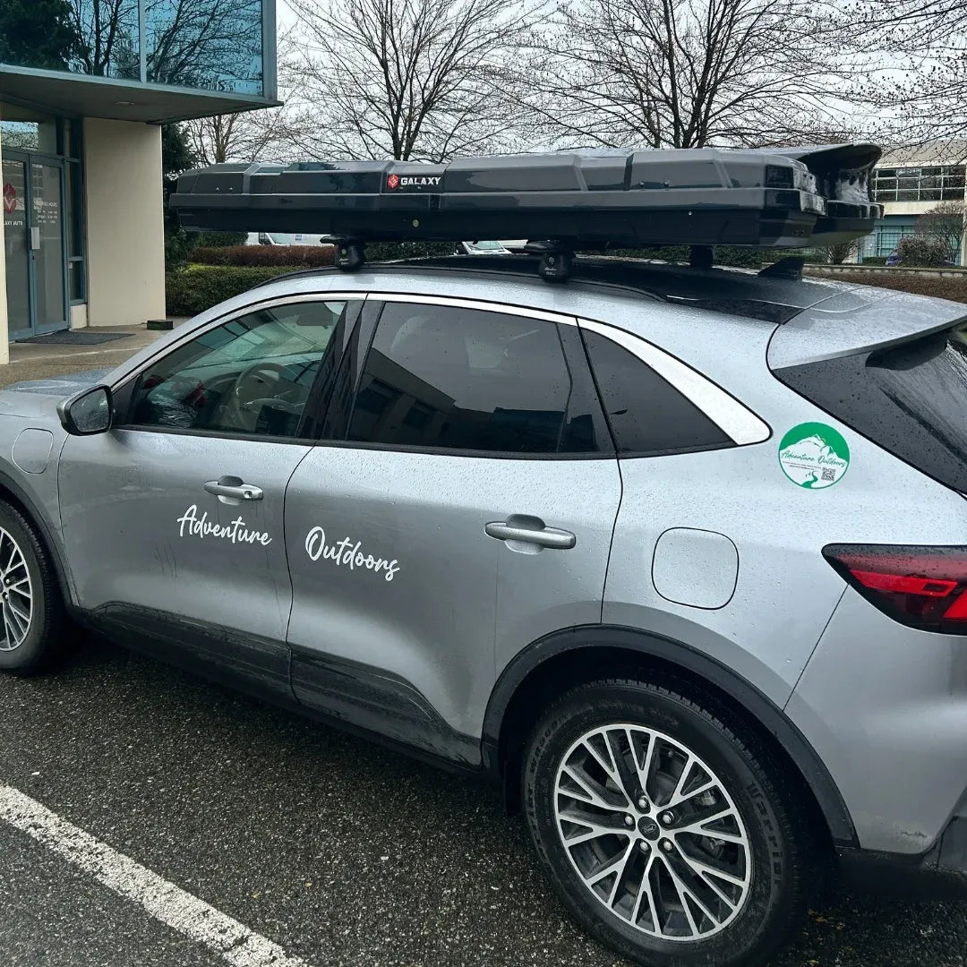 AO slim alpine cargo box mounted on silver SUV with Adventure Outdoors branding