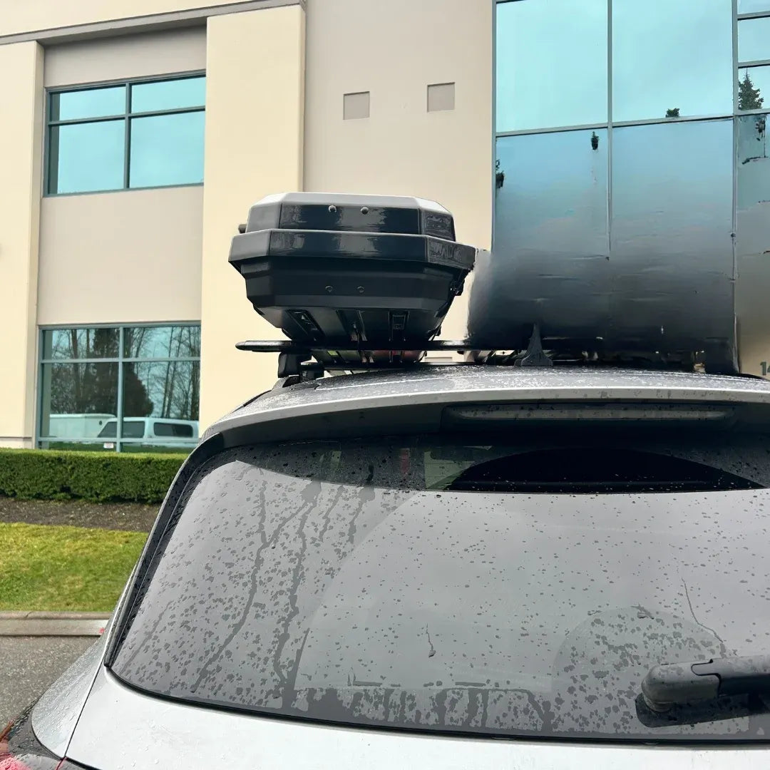 Rear three-quarter view of AO alpine cargo box on SUV parked near building