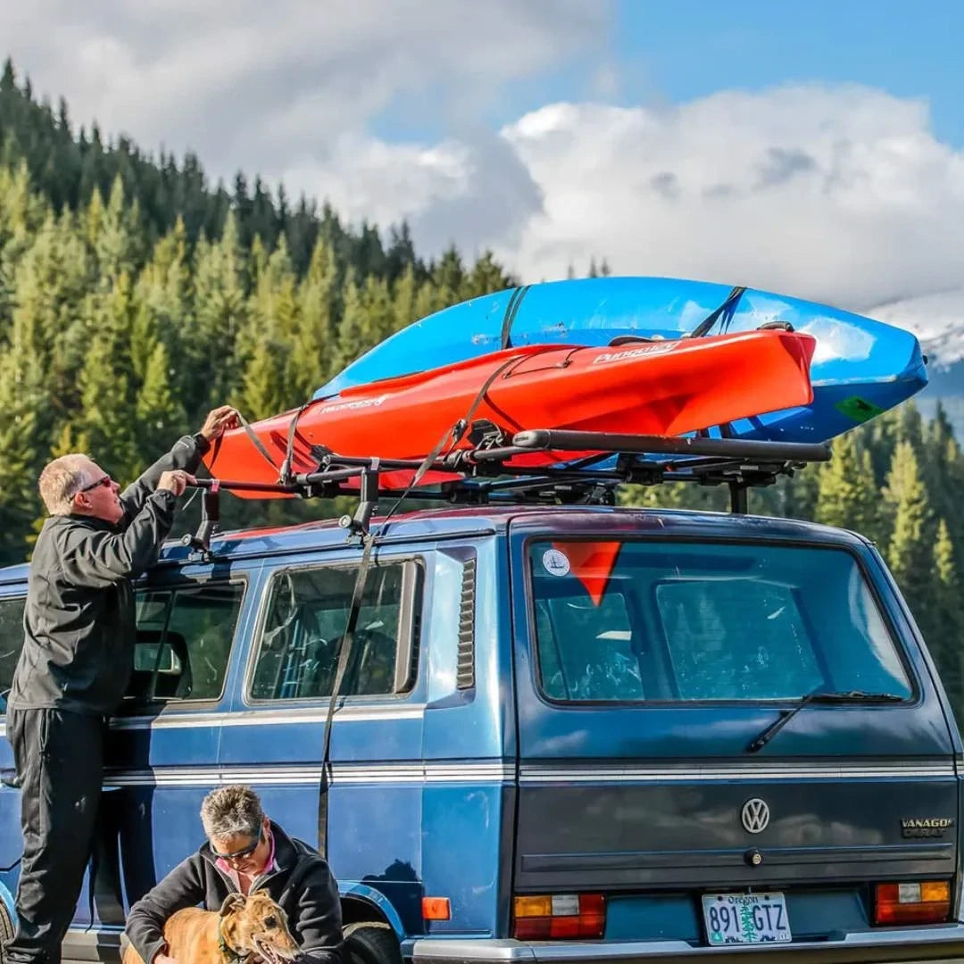Yakima SweetRoll Kayak Saddles 
Car in the mountains with kayaks strapped to the roof. Women sitting next to it with a dog.