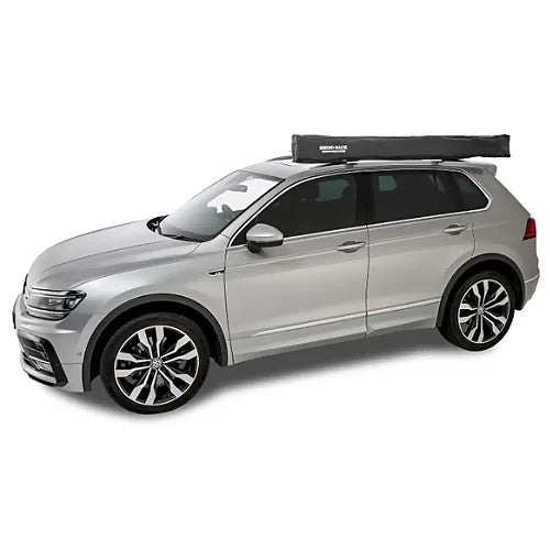 Closed Rhino-Rack Batwing Compact Awning mounted on side roof rack of SUV