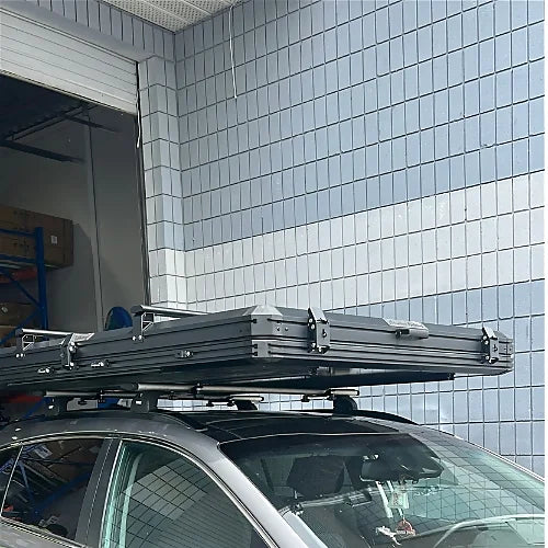 Close-up view of aluminum crossbars on closed rooftop tent mounted on black SUV roof rack
