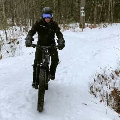 A rider wearing winter gear rides the iGO eXtreme 3.0 e-bike on a snowy trail.