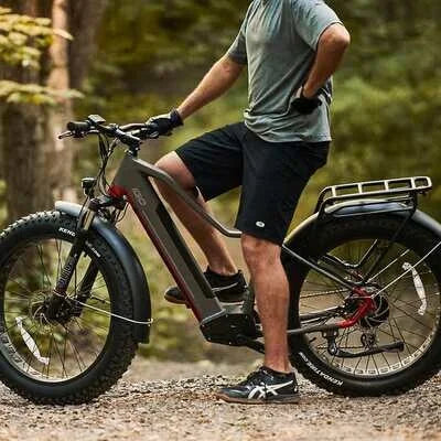 Man standing beside the iGO eXtreme 3.0 e-bike in a wooded trail environment.