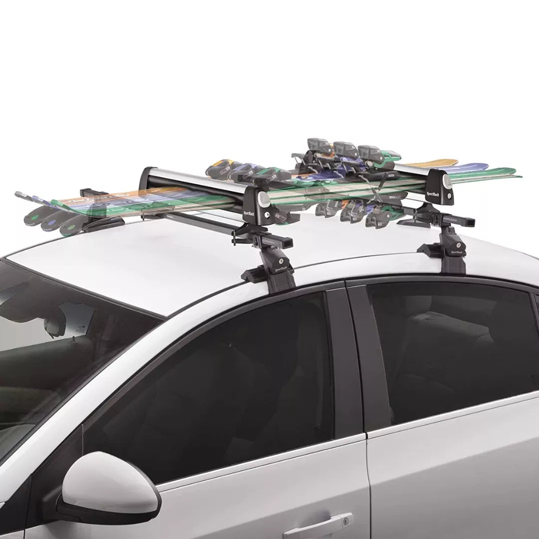 Carrier mounted on a vehicle roof holding multiple skis and snowboards.