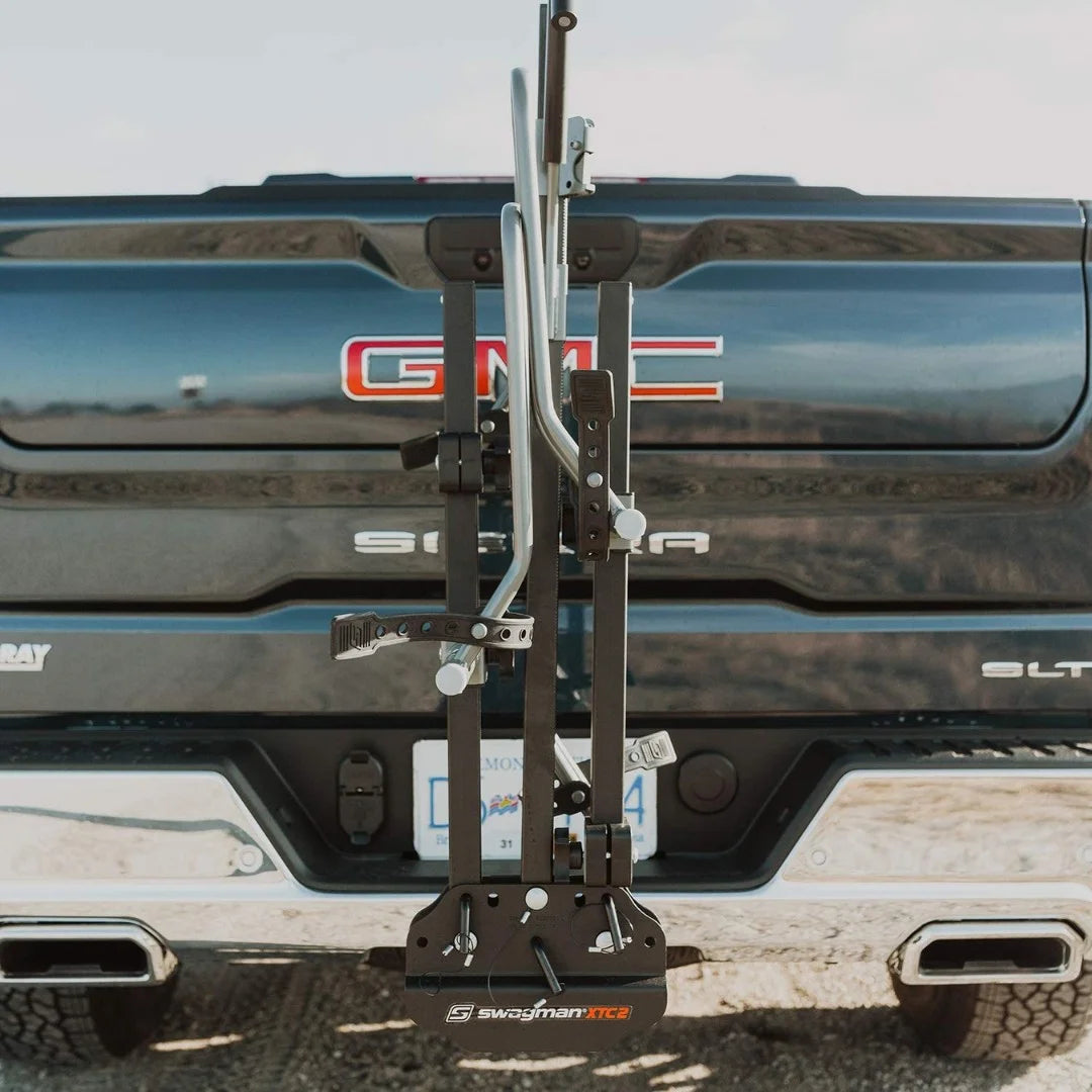 Rear view of Swagman XTC bike rack folded vertically against a truck tailgate.