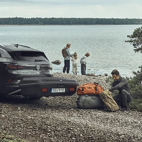 Thule Arcos Platform vehicle with family unloading cargo bags near lakeside