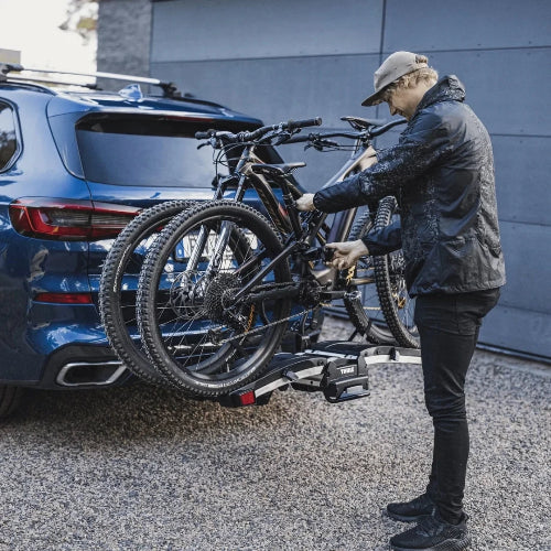 Thule EasyFold XT user mounting e-bike on rack demonstrating easy loading and AcuTight torque limiter arms