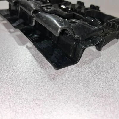 Close-up of a black plastic component on a white background