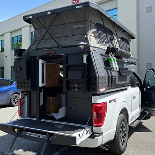 Rear view of 4th Gen truck camper installed on pickup with open entry and gear storage