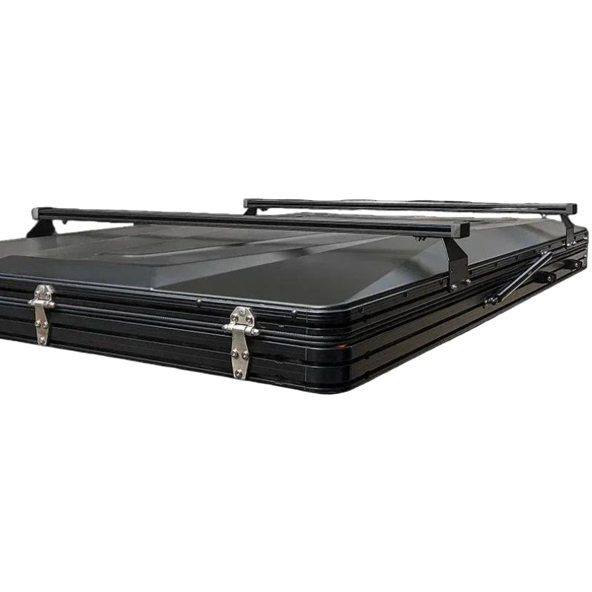 Black 6-channel crossbars mounted on top of a hard shell rooftop tent, shown from the front on a white background.