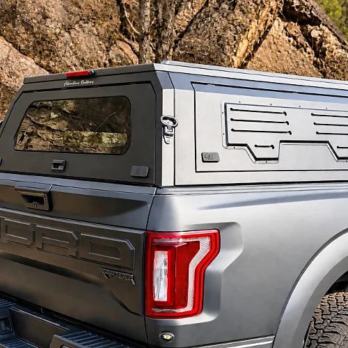 Close-up of aluminum truck cap with locking latch, key, tinted rear glass, and reinforced side door