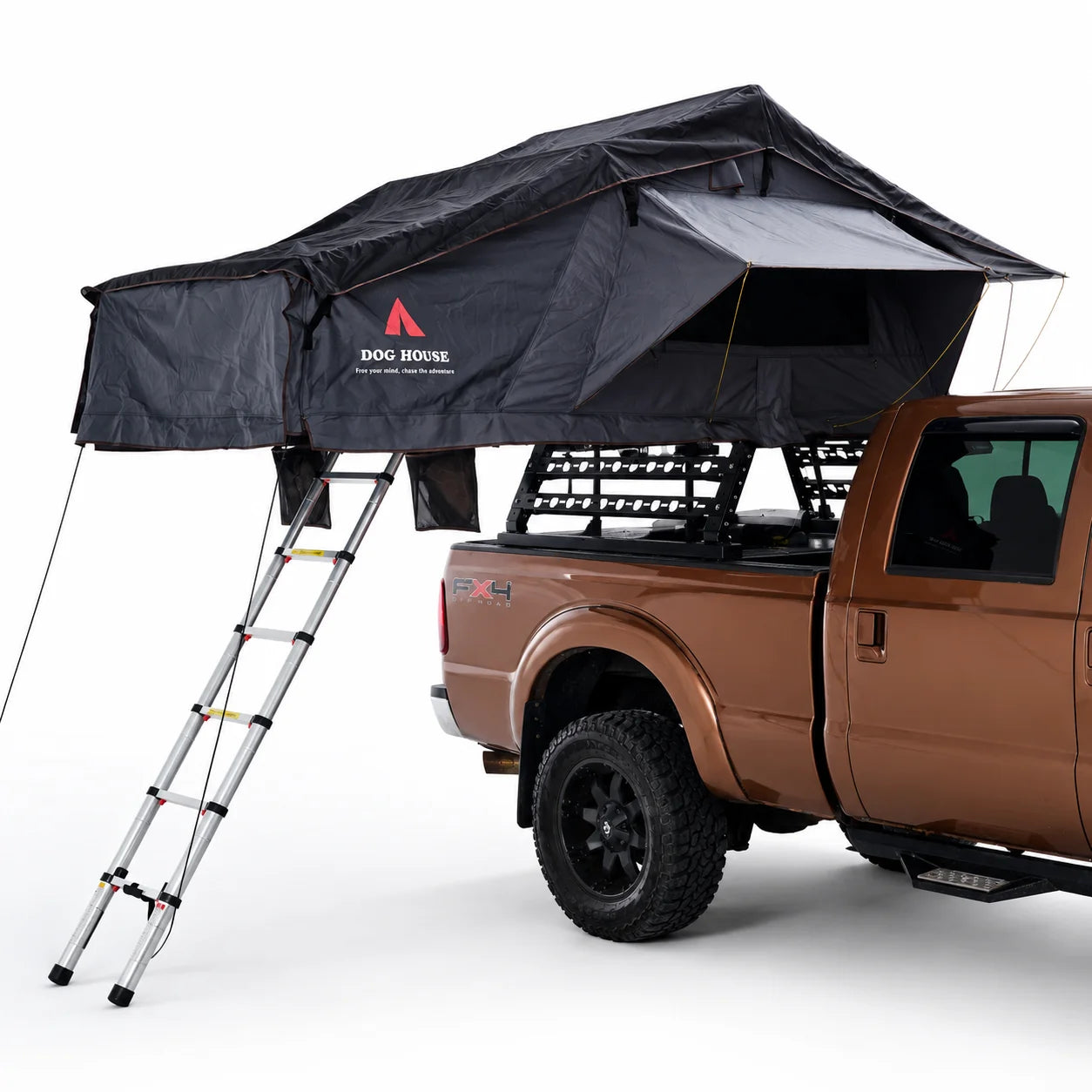 Open Doghouse Badlands soft shell rooftop tent with ladder, rainfly, and storage pockets mounted on a vehicle
