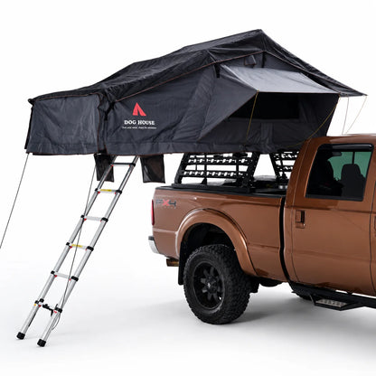 Open Doghouse Badlands soft shell rooftop tent with ladder, rainfly, and storage pockets mounted on a vehicle