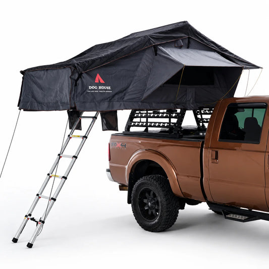Open Doghouse Badlands soft shell rooftop tent with ladder, rainfly, and storage pockets mounted on a vehicle