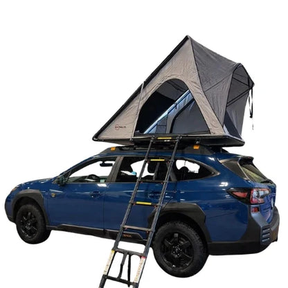 Blue SUV with a rooftop tent and ladder on a white background