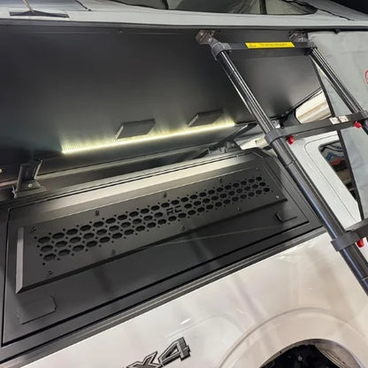 White 4x4 truck with a canopy roof rack and a open rooftop tent with lighbar for campsites