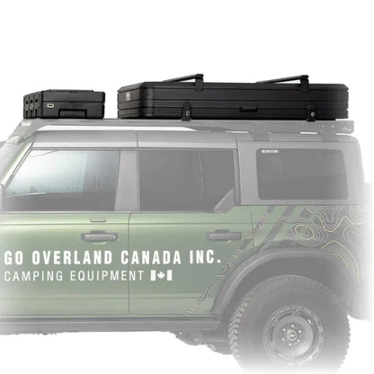 Green SUV with roof racks, cargo case, and rooftop tent and 'GO OVERLAND CANADA INC.' branding on a white background