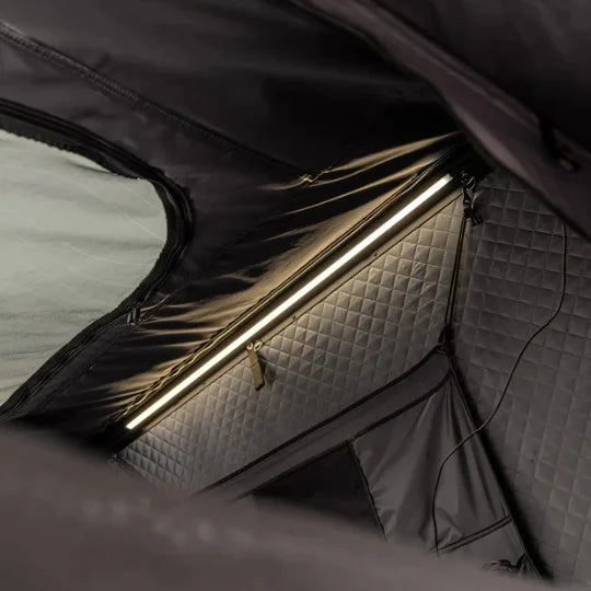 inside of go overland expedition mini rooftop tent featuring a textured interior on a gray surface highlighting LED light bar