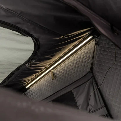 inside of go overland expedition mini rooftop tent featuring a textured interior on a gray surface highlighting LED light bar