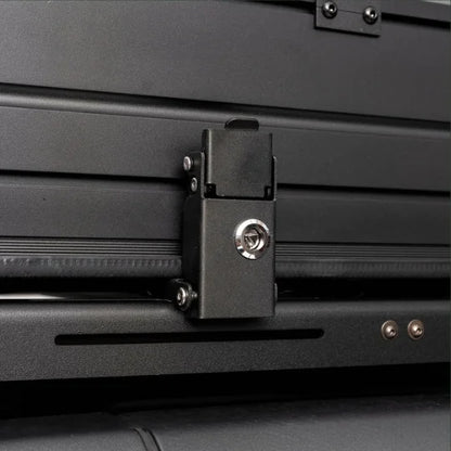 Close-up of a black lockable metal latch on a vehicle's rooftop tent.