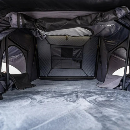 Interior of a gray rooftop tent camping tent with quilted floor and zippers.