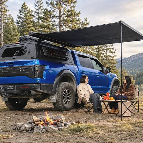 GullWing aluminum truck cap on pickup truck with roof awning, overland camping setup, tinted rear glass, and MOLLE side panel