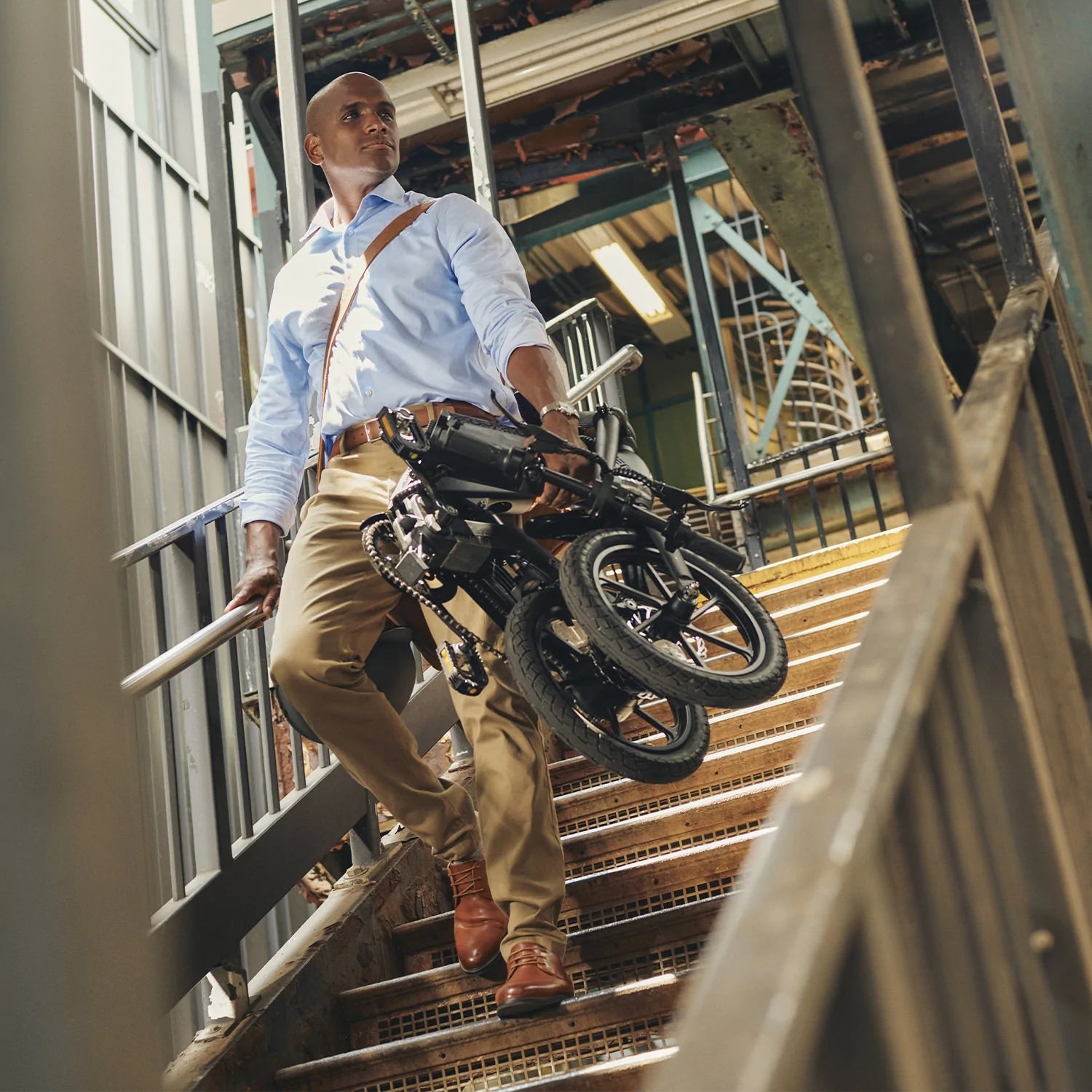Man carrying folded Jetson Haze E-Bike down a stairwell