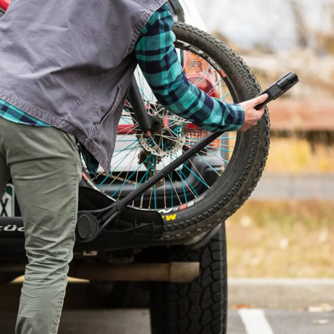 Person tightening the tire strap on the Kuat rack
