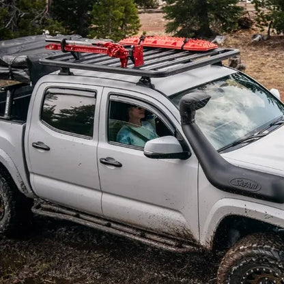 White truck with red roof rack in a natural setting