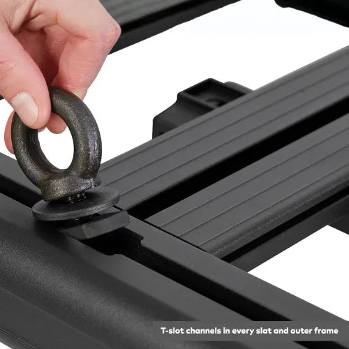 Hand attaching a ring to a black metal frame with T-slot channels.