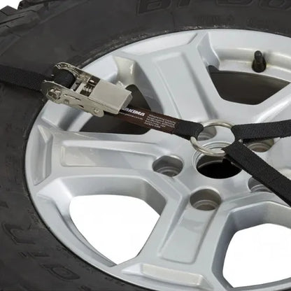 Close-up of a tire with a strap and buckle, likely used for securing cargo.